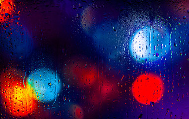 Night city lights through a wet window