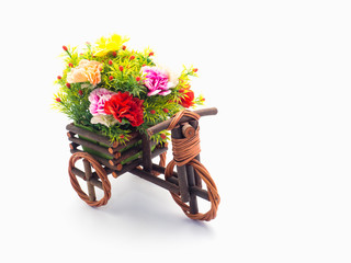 Fototapeta na wymiar Handmade wooden tricycle toy with flower in the basket isolated