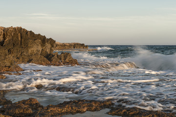Fototapeta premium Rocky shore. Sunset over the sea