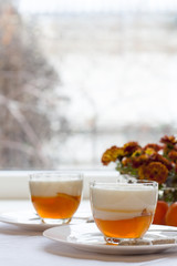 Vanilla and orange Panna Cotta in the cup on white saucer