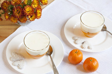Fototapeta na wymiar Vanilla and orange Panna Cotta in the cup on white saucer