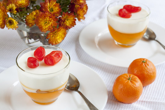 Vanilla and orange Panna Cotta in the cup on white saucer