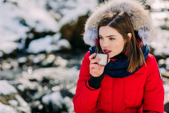 beautiful girl drinking from a thermos winter