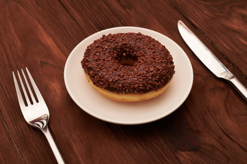 chocolate donut and fork with knife