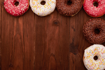 colorful donuts lying on brown wooden table