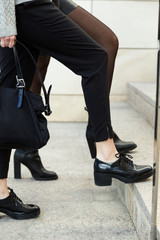 Two young businesswoman walking on the street near office building