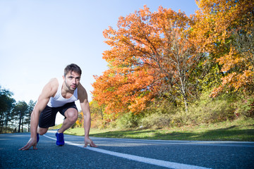 man in athletic start position outside