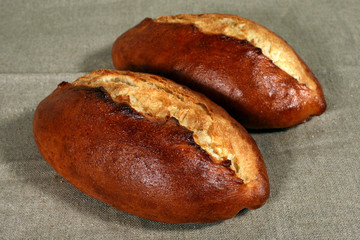 two white bread lies on a grey linen tablecloth
