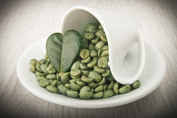 Cup of coffee with green coffee beans on the wood - 97232232
