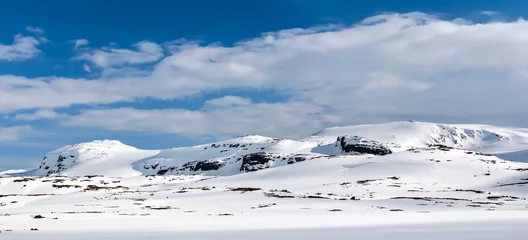 Foto op Aluminium Snowy mountain range in the sunlight. Clouds, blue sky. Winter.  Finse, Norway. © oleksandrmazur