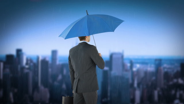 rear view of businessman holding umbrella
