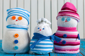 Family of handmade snowman wearing scarf and knitted cap on wooden background, merry Christmas, New...