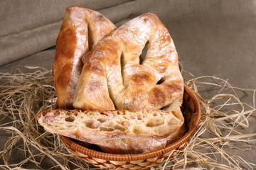 white bread is in a straw basket on the tablecloth gray linen
