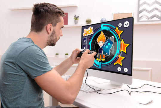 Young Man Playing Computer Games At Home