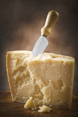 Parmesan cheese cutting on the chopping board - 97235440
