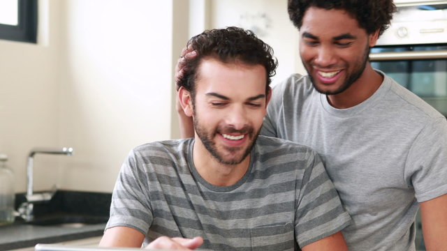 Happy homosexual couple using computer