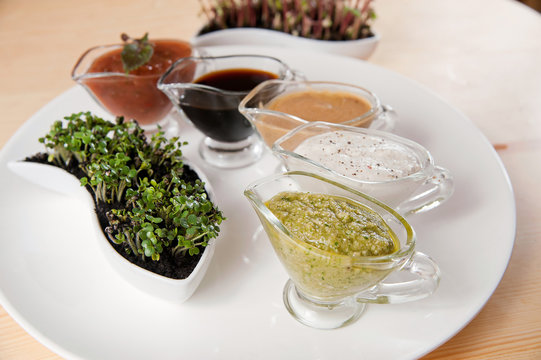 Cups of sauces sit on a table