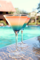 Cocktails on swimming pool background