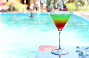 Cocktail on swimming pool background