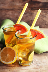 Fototapeta premium Iced tea with lemon and grapefruit on wooden background