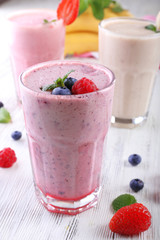 Milkshakes with berries on light wooden background, close-up