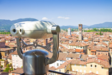 Panoramic view of Lucca seen from Guinigi tower with binocular on foreground (Italy)