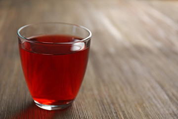 A glass of tasty garnet juice, on wooden background