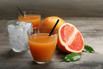 Citrus juice with ice and fresh fruits on wooden background