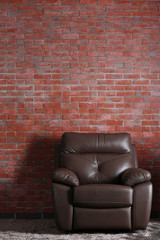 Brown leather chair on brick  wall background