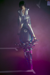 Naklejka premium brunette with latex suit mounted on a bike with a modern design