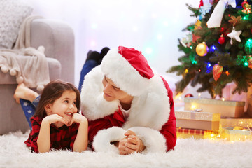 Happy father and daughter on the floor in the decorated Christmas room
