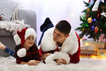 Happy father and daughter on the floor in the decorated Christmas room