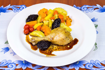 Stewed chicken legs with tomato and potato served on white plate