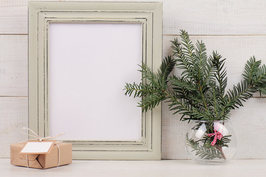 Christmas and New Year background. Empty picture frame, fir and vintage gift box with with copy space blank tag on white background. Copy space image. Scandinavian style home interior decoration