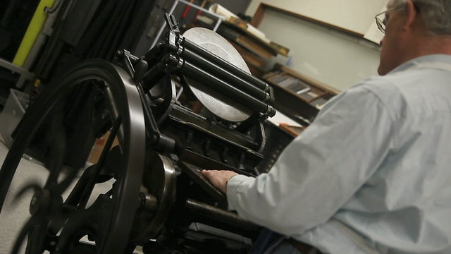 A printer demonstrates the use of a letterpress.
