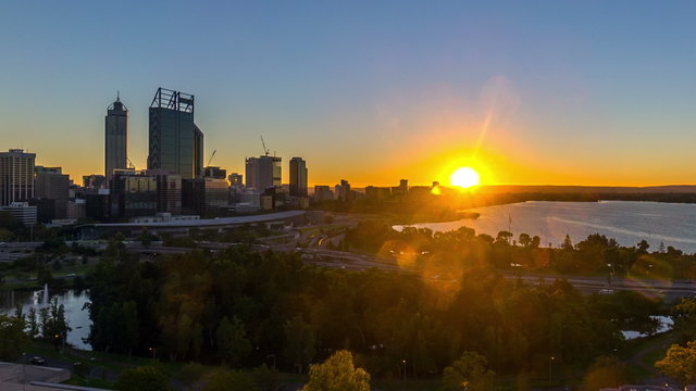 Time lapse Footage of beautiful dramatic Sunrise At Perth City, Australia. Taken from Kings Park And Botanic Garden. Showing a clear sun rise from the horizon line. Tilt up