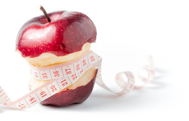 Measuring tape wrapped around apple as a symbol of diet.
