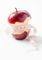 Measuring tape wrapped around apple as a symbol of diet.