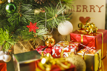Christmas decoration with gifts and present boxes under a pine tree.
Golden harmony, warm atmosphere.