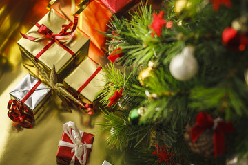 Christmas decoration with gifts and present boxes under a pine tree.
Golden harmony, warm atmosphere.