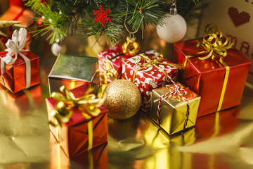 Christmas decoration with gifts and present boxes under a pine tree.
Golden harmony, warm atmosphere.