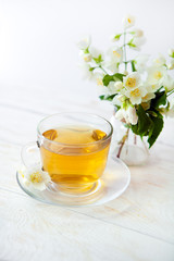 glass cup of green tea with bouquet of jasmine