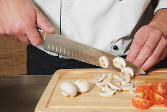 chef cutting mushrooms and tomats