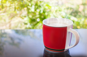 Classic red cup of black coffee and tree background