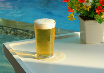 Beer mugs by swimming pool in tropical resort