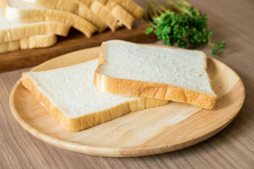 Sliced bread on the wood plate. Focused on two slices of bread on the plate.