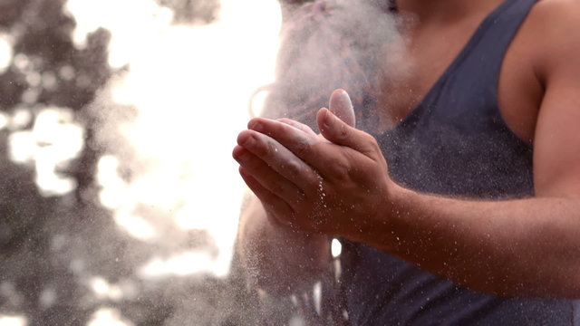 Man chalking his hands for rock climbing