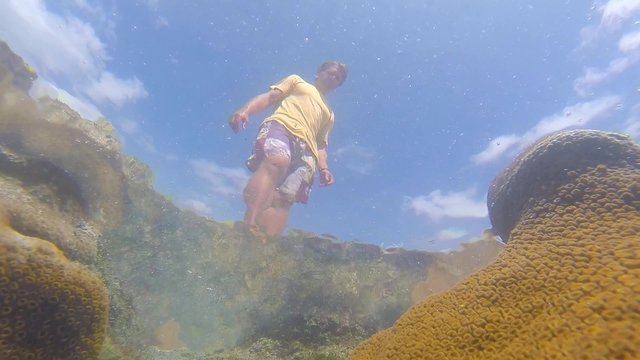 Underwater of man walking over tidepool