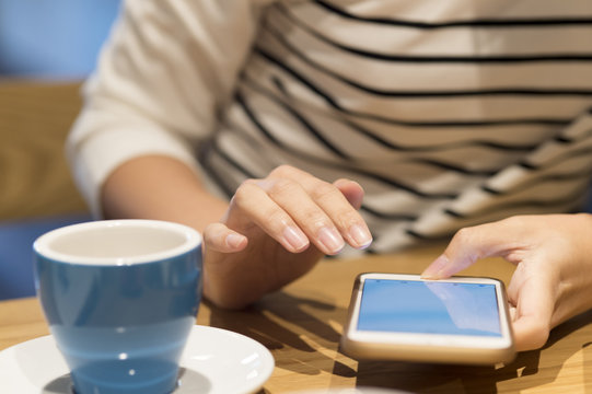 Women are using a smart phone in a cafe