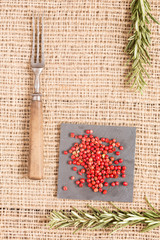 Red pepper on dark plates with rosemary and antique fork